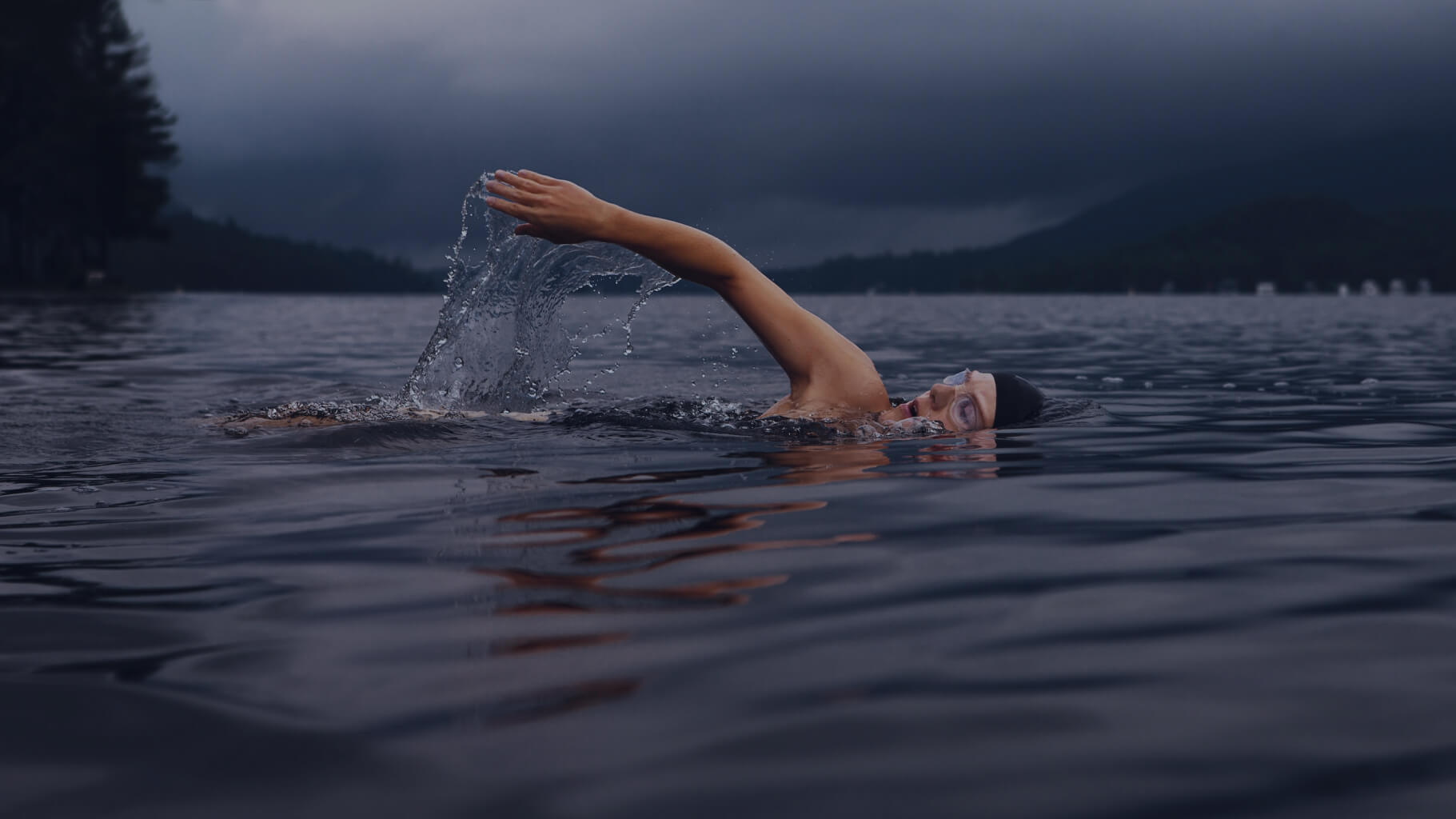 Swimmer swiming on a lake with beautiful background.